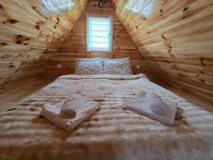 a large bed in a log cabin with towels on it at Cottage Martina in Žabljak