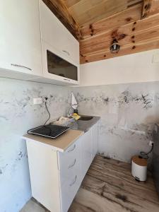 a kitchen with white cabinets and a laptop on a counter at Cottage Martina in Žabljak