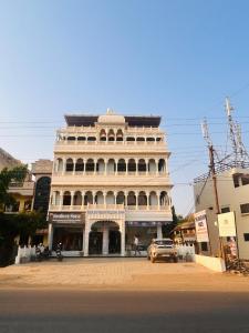 a large white building in front of a street at Shree Gurukripa Inn in Maheshwar