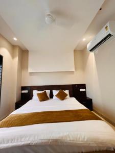 a bedroom with a large white bed with two pillows at Shree Gurukripa Inn in Maheshwar