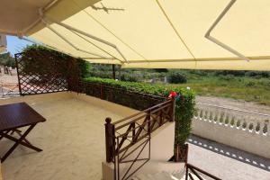 a large umbrella on a balcony with a table at Two-floor house next to sea in Loutraki +28 photos