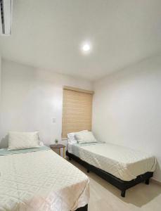 a bedroom with two beds and a window at Almarena Mazatlan Departamento Nautico in Mazatlán
