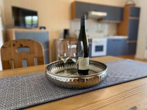 a bottle of wine and two wine glasses on a table at Moselurlaub im Ferienweinhaus Koch in Neumagen-Dhron +3 photos