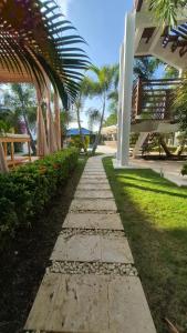 a stone walkway in a park with palm trees at Oasis Tolú Hotel Boutique in Tolú +15 photos