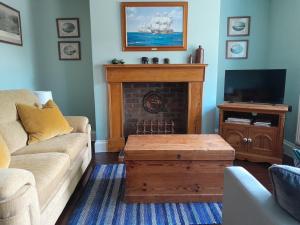 a living room with a couch and a fireplace at The Captain's House Charlestown St Austell in Charlestown