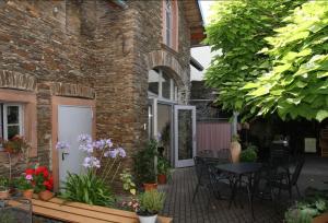 a patio with a table and chairs in front of a building at Moselurlaub im Ferienweinhaus Koch in Neumagen-Dhron