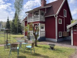 a red house with chairs and a table in the yard at Sommerhaus Luisa in Vimmerby