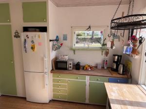 a kitchen with a white refrigerator and a window at Sommerhaus Luisa in Vimmerby