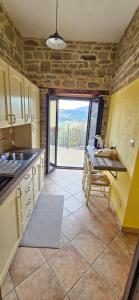eine Küche mit Spüle und Tisch mit Aussicht in der Unterkunft PASCHIERE by Keyhole Selection in Castelmezzano