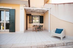 a patio with a chair and a table with a blue pillow at Mediterranea Modica - Seaside Home in Marina di Modica