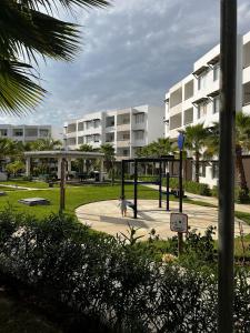 a playground in a park in front of a building at Almarena Mazatlan Departamento Nautico in Mazatlán