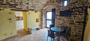 eine Küche mit einer Backsteinwand und einem Tisch mit Stühlen in der Unterkunft PASCHIERE by Keyhole Selection in Castelmezzano + 36 Fotos