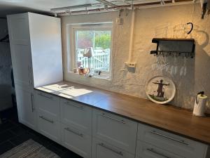 a kitchen with white cabinets and a window at Lägenhet Övergran in Bålsta +23 photos