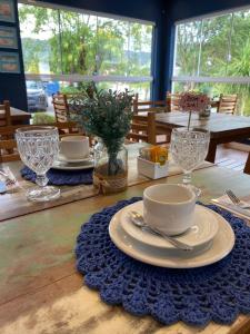 a wooden table with plates and glasses on it at Morada do Estaleiro in Balneário Camboriú
