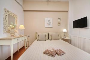 a white bedroom with a bed with two towels on it at Aeraki Home in Skopelos Town