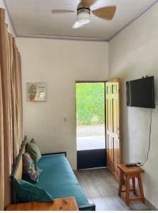 a bedroom with a bed and a tv and a window at Serenity House in Cahuita +11 photos