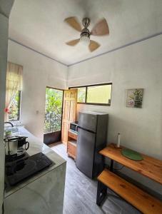 a kitchen with a stainless steel refrigerator and a table at Serenity House in Cahuita