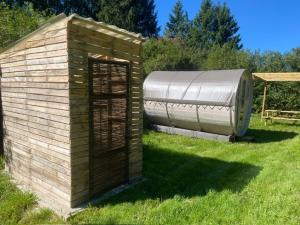 ein kleines Gebäude im Gras auf einem Feld in der Unterkunft Le tonneau in Sivry