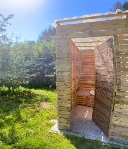 ein Holzgebäude mit Toilette auf einem Feld in der Unterkunft Le tonneau in Sivry