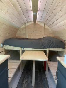 Ein Blick ins Innere eines Minihauses mit einem Bett in der Unterkunft Le tonneau in Sivry