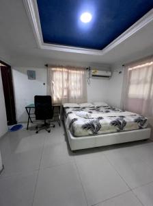 a bedroom with a bed and a desk in it at Lohana's House Beach in Cartagena de Indias