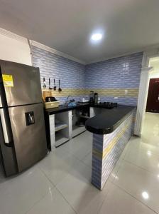 a kitchen with a stainless steel refrigerator and a counter at Lohana's House Beach in Cartagena de Indias +3 photos