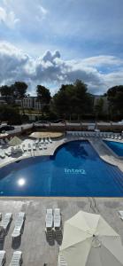 a large swimming pool with lounge chairs and umbrellas at NUEVOS 2026 ESTRENA PRECIOSO APARTHOTEL INTER2, NEW APARTMENTS lN SALOU! self check in! PARKING! PORT AVENTURA in Salou