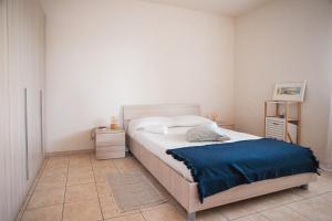 a bedroom with a bed with a blue blanket on it at Mediterranea Modica - Seaside Home in Marina di Modica