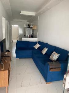 a blue couch in a living room with a kitchen at Casa Arembepe 2 in Camaçari