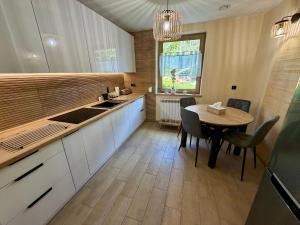 a kitchen with a table and a dining room at Leśny Reset in Imielnia
