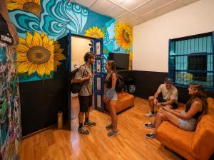 a group of people in a room with sunflowers on the wall at Lienzo Hostal Popayán in Popayan +13 photos