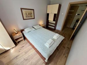 a bedroom with a bed with towels on it at Leśny Reset in Imielnia