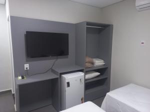 a room with a tv and a small refrigerator at Hotel Parada KM364 in Santo Antonio do Rio Abaixo