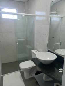 a bathroom with a toilet and a sink and a shower at Hotel Parada KM364 in Santo Antonio do Rio Abaixo