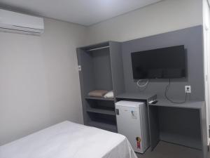 a room with a bed and a tv and a room with a bed sidx sidx at Hotel Parada KM364 in Santo Antonio do Rio Abaixo