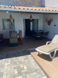 a patio with a lounge chair and a table at Casa Arembepe 2 in Camaçari