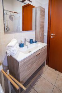 a bathroom with a sink and a mirror at Mediterranea Modica - Seaside Home in Marina di Modica +27 photos