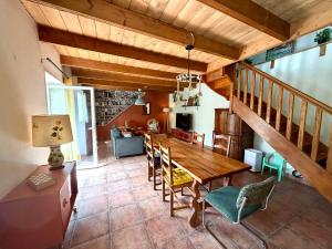 a kitchen and dining room with a wooden table and chairs at Maison bretonne, Gîte de Keranglaz in Ploubezre