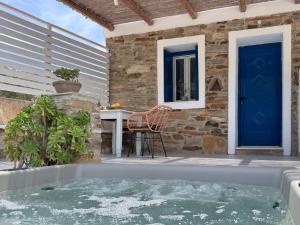 a hot tub on a patio with a blue door at Aloni Ios in Mylopotas +17 photos