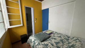 a small bedroom with a bed with a book on it at POA Eco Hostel in Porto Alegre