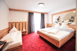 a bedroom with two beds and a red carpet at Hotel Traube in Fliess +141 photos