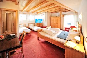 a large room with two beds and a desk at Hotel Traube in Fliess