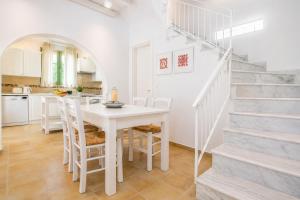 a kitchen and dining room with a table and stairs at Villa Mytikas in Gennadi