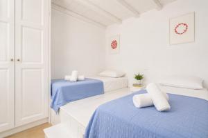 two beds in a white room with blue sheets at Villa Mytikas in Gennadi +11 photos