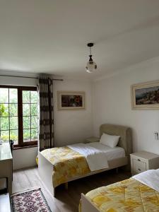 a bedroom with two beds and a window at Oda Kuksit Hotel in Kukës