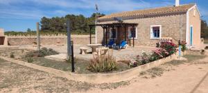 a garden in front of a small house with flowers at Finca Blanca Formentera in Sant Francesc Xavier