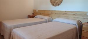 two twin beds in a room with wooden walls at Finca Blanca Formentera in Sant Francesc Xavier