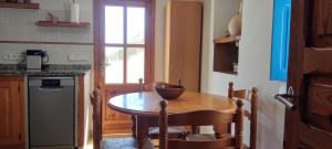 a small kitchen with a wooden table and a window at Finca Blanca Formentera in Sant Francesc Xavier