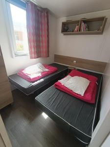 two bunk beds in a small room with a window at Mobil'home Valras in Valras-Plage +19 photos