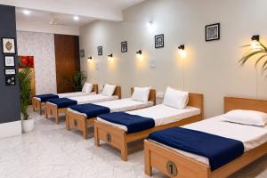 four beds lined up in a row in a room at Rahat Dormitory in Jāmb